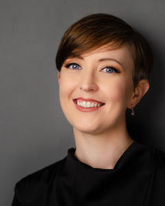 A close up photo of Sarah looking straight into the camera, smiling widely